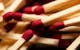 Macro image of red-tipped wooden matchsticks, ideal for fire starting concepts.