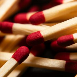 Macro image of red-tipped wooden matchsticks, ideal for fire starting concepts.